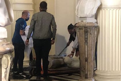 Personal de Casa Rosada junto al busto del expresidente Hipólito Yrigoyen