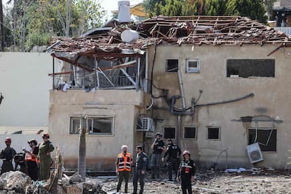 Personal de emergencia y fuerzas de seguridad trabajan en el lugar donde un proyectil impactó sobre una casa en Eshtaol, en el centro de Israe (Ahmad GHARABLI /AFP)