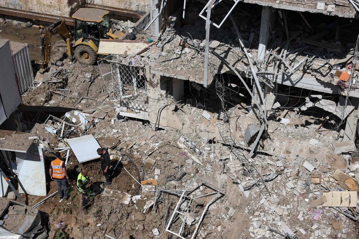 Personal de los servicios de emergencia israelíes se reúne en el lugar de un ataque con misiles iraníes en Tel Aviv el 24 de marzo de 2026 (Foto de Odd ANDERSEN / AFP)