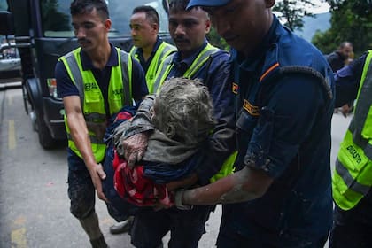 Personal de rescate traslada a una persona afectada por inundaciones repentinas en Devghat, en el distrito de Nuwakot, Nepal