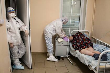 Personal de salud, con equipos de protección, atienden a una persona con COVID-19 en la UCI del hospital de enfermedades infecciosas número 2 de Nizhny Novgorod, Rusia, el 20 de octubre de 2021. ​(AP Foto/Roman Yarovitcyn)