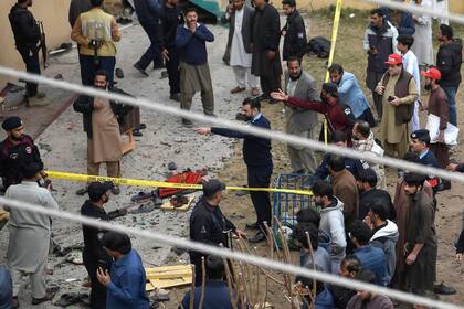 Personal de seguridad y residentes locales se reúnen en el lugar de una explosión dentro de una mezquita en Islamabad