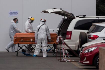 Personal de un hospital de Santiago de Chile lleva un ataúd por el aumento de muertos por coronavirus