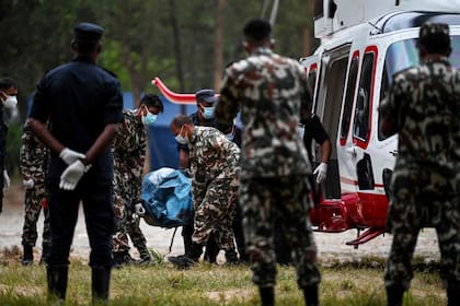 Personal del ejército traslada los cuerpos de víctimas desde un helicóptero en el campamento de Trishuli, en el distrito nepalí de Nuwakot, el 31 de agosto de 2026 (Arun Sankar/ AFP)