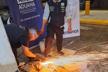 Personal especializado corta con amoladora un cricket hidráulico para extraer la droga oculta, en el puesto de control fronterizo