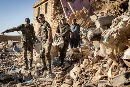 Personal militar traslada un cuerpo en el pueblo de Tafeghaghte, devastado por el terremoto. (FADEL SENNA / AFP)