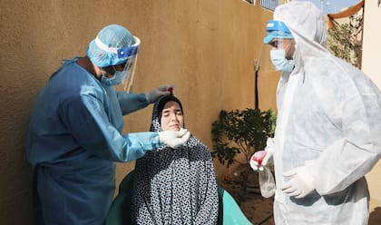 Personal sanitario palestino realiza un hisopado a un residente en el sur de la Franja de Gaza