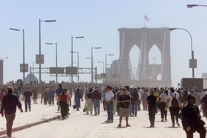 Personas abandonan Manhattan a pie rumbo a Brooklyn después de que los puentes fueran cerrados tras el derrumbe del World Trade Center