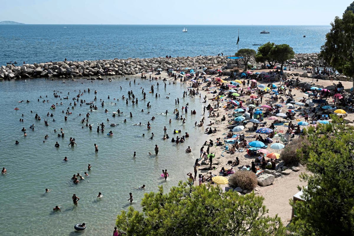 Personas bañándose en la «Plage des Corbières» en el puerto de cercanías de L'Estaque, en Marsella
