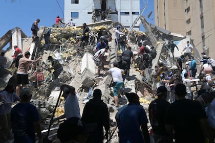 Personas buscan supervivientes entre los escombros de un edificio derrumbado tras un terremoto en Cali, Colombia