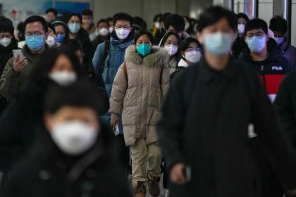 Personas caminan en una estación de metro en Pekín el martes 20 de diciembre de 2022. (AP Foto/Andy Wong)