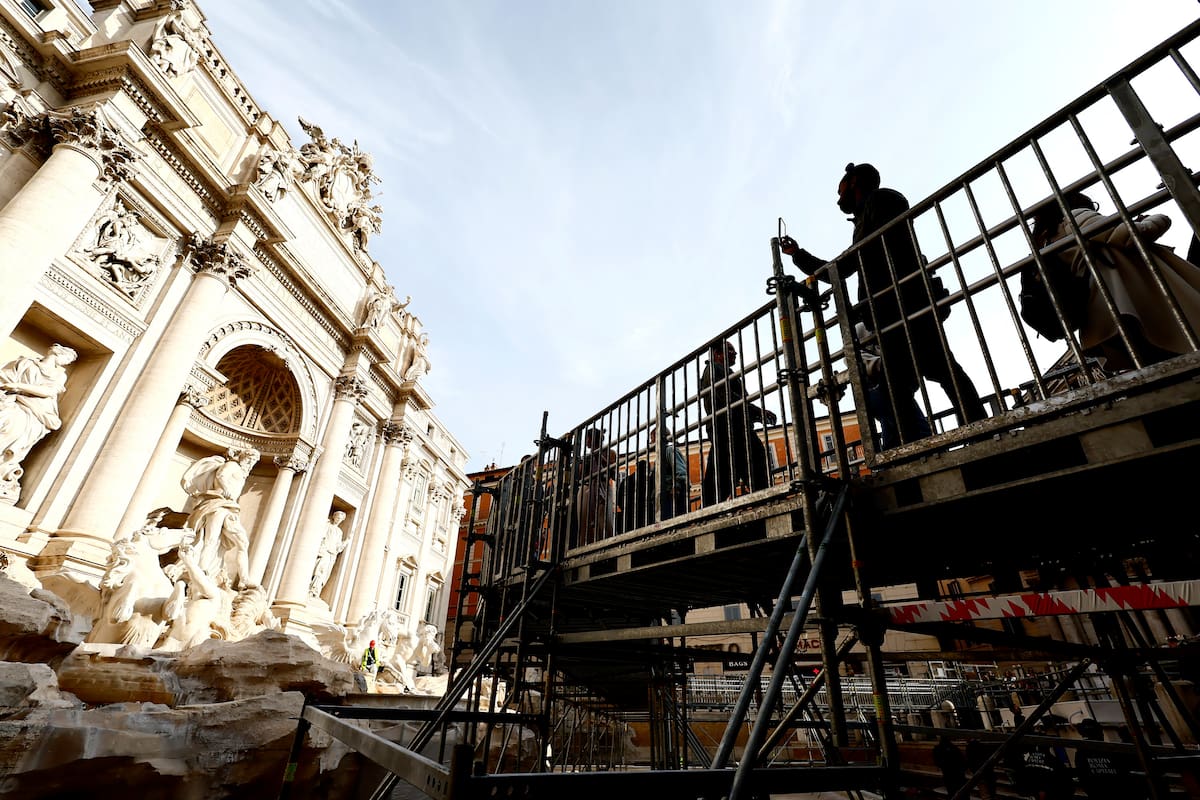 Personas caminan por una pasarela elevada que da acceso limitado a la Fuente de Trevi durante trabajos de mantenimiento en Roma (Cecilia Fabiano/LaPresse vía AP)