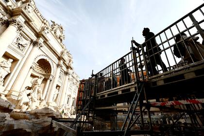 Personas caminan por una pasarela elevada que da acceso limitado a la Fuente de Trevi durante trabajos de mantenimiento en Roma (Cecilia Fabiano/LaPresse vía AP)