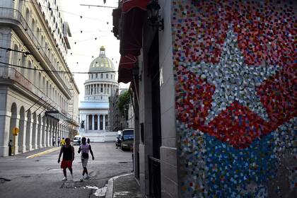 Personas caminando por una calle mientras ocurre una desconexión del Sistema Eléctrico Nacional (SEN), en La Habana, capital de Cuba