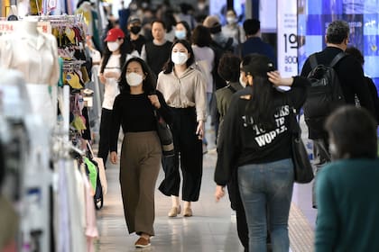 Personas con barbijos caminan por una zona comercial subterránea en Seúl el 6 de mayo de 2020