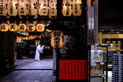 Personas con máscaras faciales dentro de un santuario cerca del mercado Nishiki de Kyoto el 22 de mayo de 2020