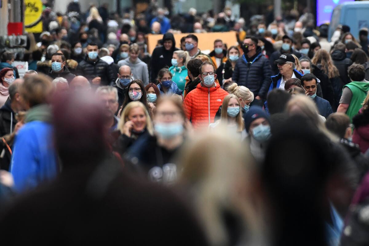 Personas con mascarillas caminan por la zona peatonal de la ciudad de Dortmund, en el oeste de Alemania, el 14 de octubre de 2020, en medio de la pandemia del nuevo coronavirus