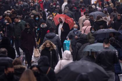 Personas con mascarillas para frenar la propagación de COVID-19 caminan por las calles del centro de Madrid, el viernes 24 de diciembre de 2021. (AP Foto/Manu Fernández)