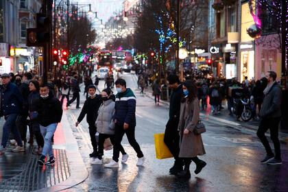 Personas cruzan la calle Oxford en Londres, el lunes 27 de diciembre de 2021. (AP Foto/David Cliff)