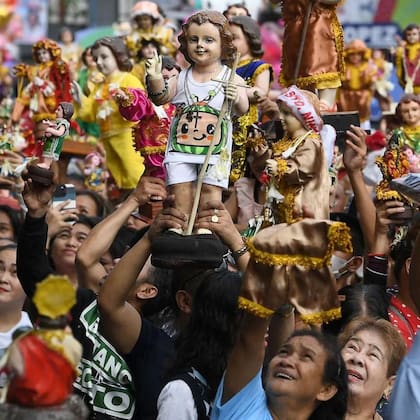 Personas en Manila sosteniendo figuras del Santo Niño Jesús, un ícono introducido en Filipinas por Magallanes.