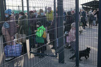 Personas esperan cruzar de las zonas controladas por separatistas prorrusos hacia regiones controladas por el gobierno ucraniano en Stanytsia, Luhanska, en el este de Ucrania, el martes 22 de febrero de 2022. (AP Foto/Vadim Ghirda)
