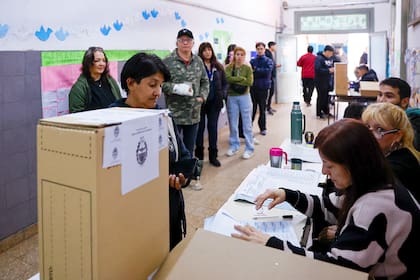Personas esperan en una mesa de votación en Lanús, provincia de Buenos Aires