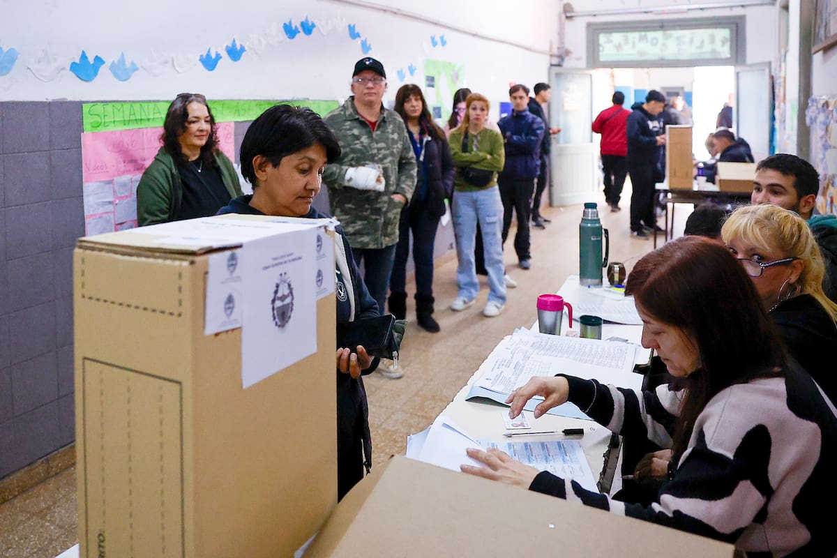 Personas esperan en una mesa de votación este domingo, durante la jornada de elecciones legislativas, en un colegio de Lanús