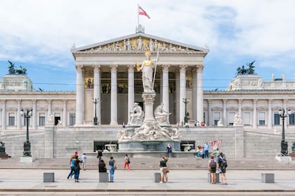 Personas frente al edificio del Parlamento austriaco en Ringstrasse