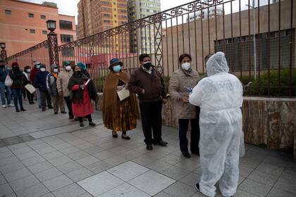 Personas hacen fila para aplicarse la vacuna Sinopharm COVID-19 dentro de la Universidad Mayor de San Andrés en el marco del plan de inmunización de mayores de 50 años en La Paz, Bolivia, el lunes 17 de mayo de 2021