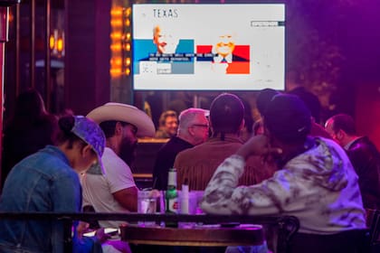 Personas miran los resultados de las elecciones en un restaurante en West Hollywood, California