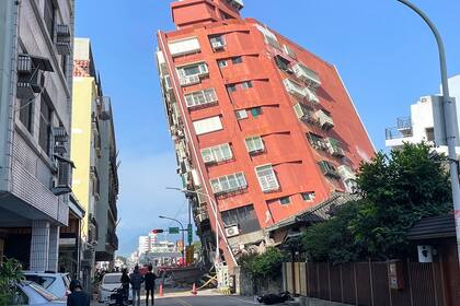 Personas miran un edificio dañado en Hualien, después de que un gran terremoto azotara el este de Taiwán