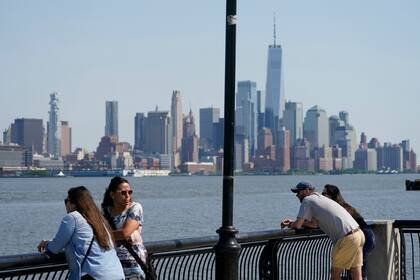 Personas observan el horizonte de la ciudad de Nueva York desde Hoboken, Nueva Jersey, el miércoles 19 de mayo de 2021. (AP Foto/Seth Wenig)