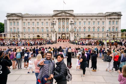 Personas observan la ceremonia de Cambio de Guardia en el Palacio de Buckingham, Londres, el lunes 23 de agosto de 2021. (AP Foto/Alberto Pezzali)