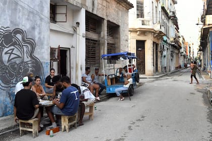 Personas participando en un juego de mesa en una calle mientras ocurre una desconexión del Sistema Eléctrico Nacional (SEN), en La Habana, capital de Cuba