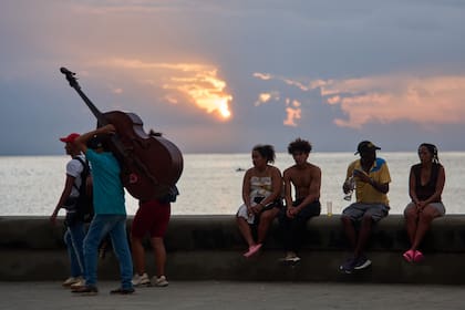 Personas pasan el tiempo sentadas en el muro del Malecón durante un apagón en La Habana, Cuba, el viernes 10 de julio de 2026