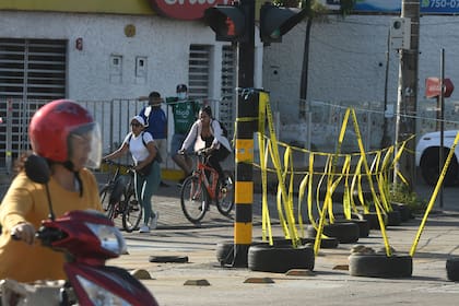 Personas pasan por un bloqueo en el centro de Santa Cruz durante el paro cívico de 24 horas convocado por las autoridades locales en protesta por la detención del gobernador Luis Fernando Camacho, el 30 de diciembre de 2022. (RODRIGO URZAGASTI / AFP)