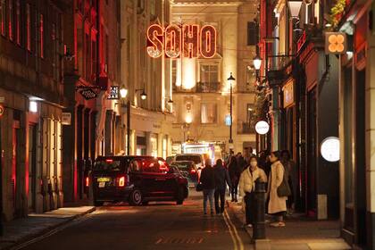 Personas pasean por Soho, en Londres, el jueves 30 de diciembre de 2021. (Jonathan Brady/PA vía AP)