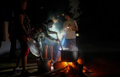 Personas preparan una sopa en una fogata durante un apagón que siguió a la falla de una importante planta energética en La Habana, Cuba, el 19 de octubre de 2024. (AP/Ramón Espinosa)