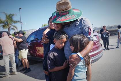 Personas se abrazan afuera de la granja Glass House Farms, el viernes 11 de julio de 2025, en Camarillo, California, un día después de que agentes federales de inmigración realizaron una redada