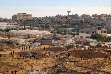 Personas se encuentran alrededor de cráteres causados por bombardeos israelíes en Rafah, en el sur de la Franja de Gaza, el 12 de febrero de 2024.