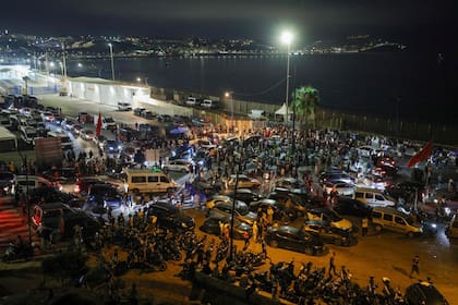 Personas se reúnen en Bab Sebta, en la frontera entre Marruecos y España —cerca del enclave español de Ceuta y de la localidad marroquí de Fnideq—, el 30 de julio de 2026. Cientos de personas convergían en la localidad marroquí de Fnideq la tarde del 30 de julio tras difundirse rumores de que se había abierto la frontera con Ceuta, según un periodista de la AFP. Previamente, España había informado de nueve fallecimientos después de que cientos de migrantes entraran en el enclave norteafricano desde Marruecos, principalmente a nado