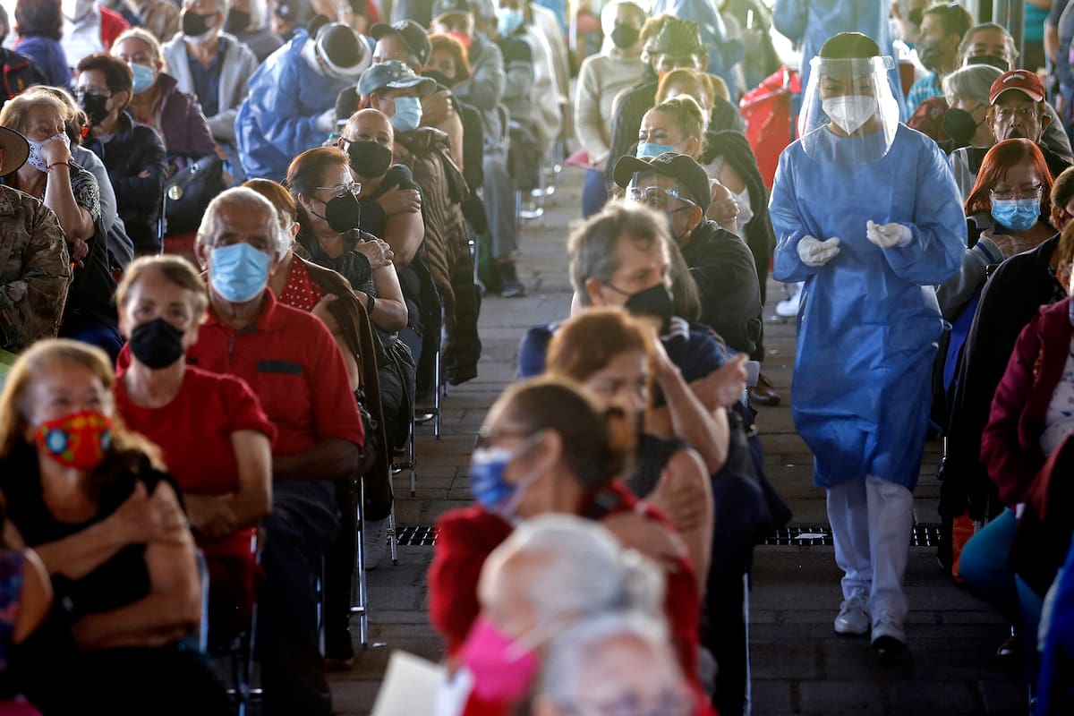 Personas sentadas tras recibir una dosis de la vacuna de Pfizer-BioNTech contra la Covid-19 en el centro de vacunación instalado en el Instituto Cabanas en Guadalajara, estado de Jalisco, México, el 21 de marzo de 2021