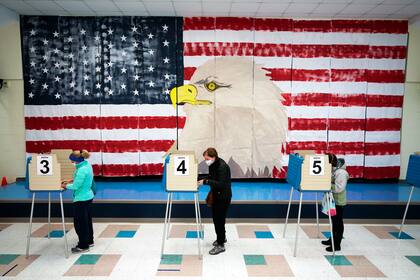 Personas votan frente a un enorme mural el 3 de noviembre de 2020 en la Escuela Primaria Robious, en Midlothian, Virginia.  (AP Foto/Steve Helber, Archivo)