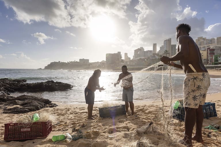 Pescadores desenredan sus redes en la playa de Rio Vermelho, frente a la Casa de Iemanjá.