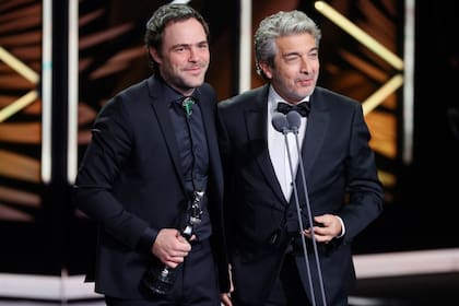 Peter Lanzani y Ricardo Darín mientras recibían el galardón de mejor guion coescrito en los Premios Platino