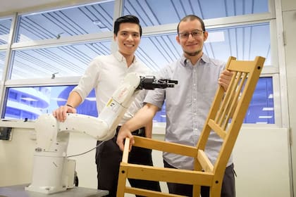 Pham Quang Cuong y Francisco Suárez-Ruiz, investigadores de la Universidad Tecnológica Nanyang de Singapur, posan con una silla Ikea armada por un robot