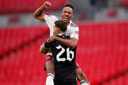 Pierre-Emerick Aubameyang acaba de convertir el penal decisivo y se abraza con el arquero argentino Emiliano Martínez. Los dos fueron fundamentales para que Arsenal venciera a Liverpool, campeón de la Premier, y se quedara con la Community Shield en Wembley.