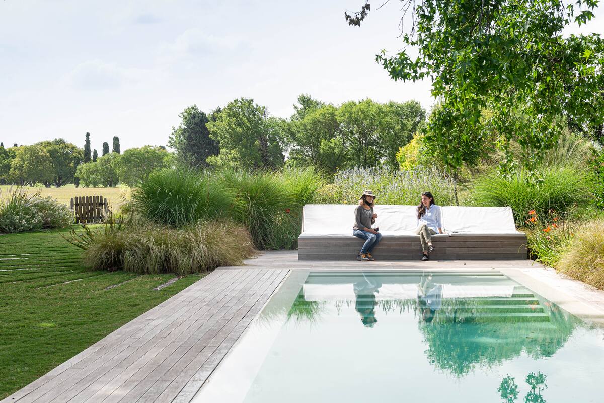 Pileta con solárium y camastro que fueron envueltos con una plantación curva de Miscanthus gracillimus, Nassella tenuissima, Phlomis fruticosa, Pennisetum alopecuroides ‘Hameln’ y P. alopecuroides‘Moudr y’, Salvia uliginosa, Hemerocallis ‘Merle Kent’, Carex ‘Montana’ y C. ‘Phoenix’. El árbol es Koelreuteria paniculata, y se dejó el Baccharis dracunculifolia y los Senecio bonariensis espontáneos.