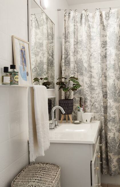 Pintar los azulejos, poner dos espejos en vez de uno, una planta y un toallero moderno transformaron el baño