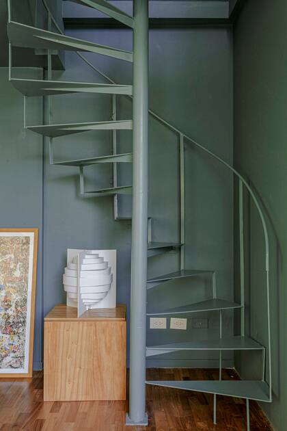 Pintaron la escalera y la pared en 'Verde Petróleo’ (paleta de Mesopotamia para Sherwin Williams) para fundir ambos planos